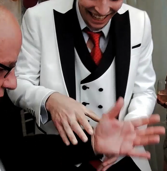 Corporate magician performing close-up magic at a luxury gala event.